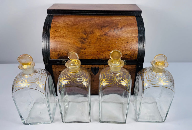 Antique Georgian boxed decanter set with mahogany case, four square glass spirit decanters and gilt stoppers