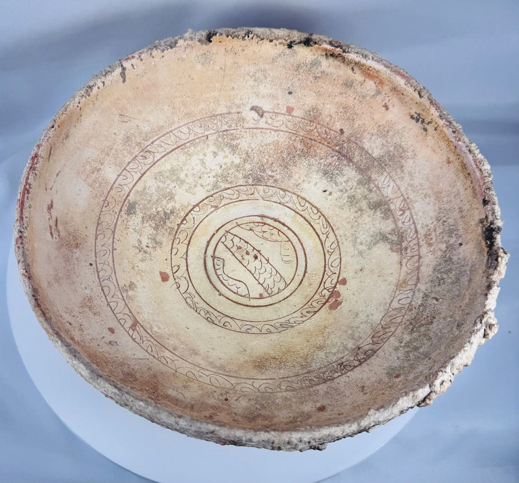 Ancient Eastern Mediterranean ceramic bowl with cream slip decoration and centuries of archaeological weathering.