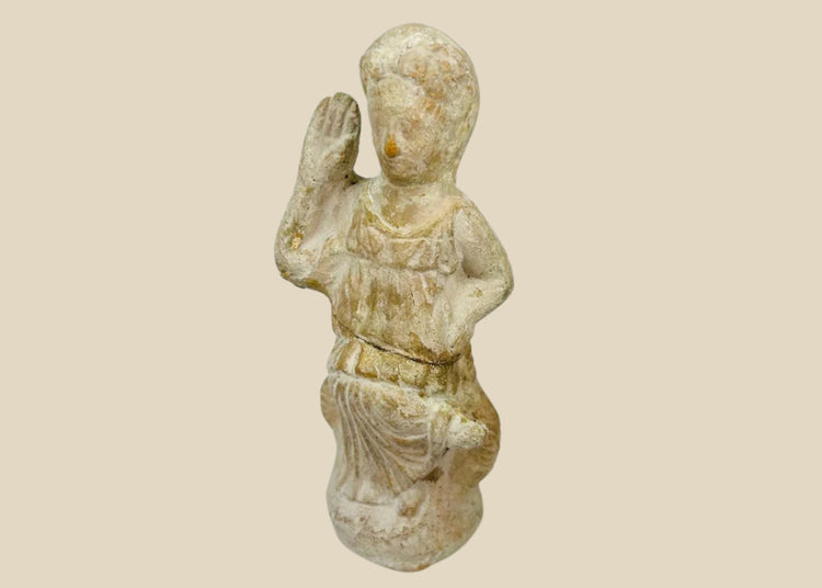 Terracotta figurine of Isis, 1st–3rd century CE, with draped attire, raised hand of blessing, and natural aged patina, blending Egyptian and Roman styles.