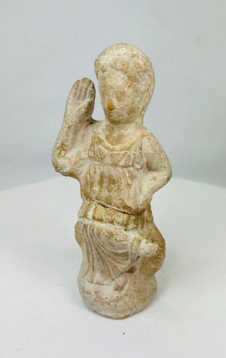 Terracotta figurine of Isis, 1st–3rd century CE, with draped attire, raised hand of blessing, and natural aged patina, blending Egyptian and Roman styles.