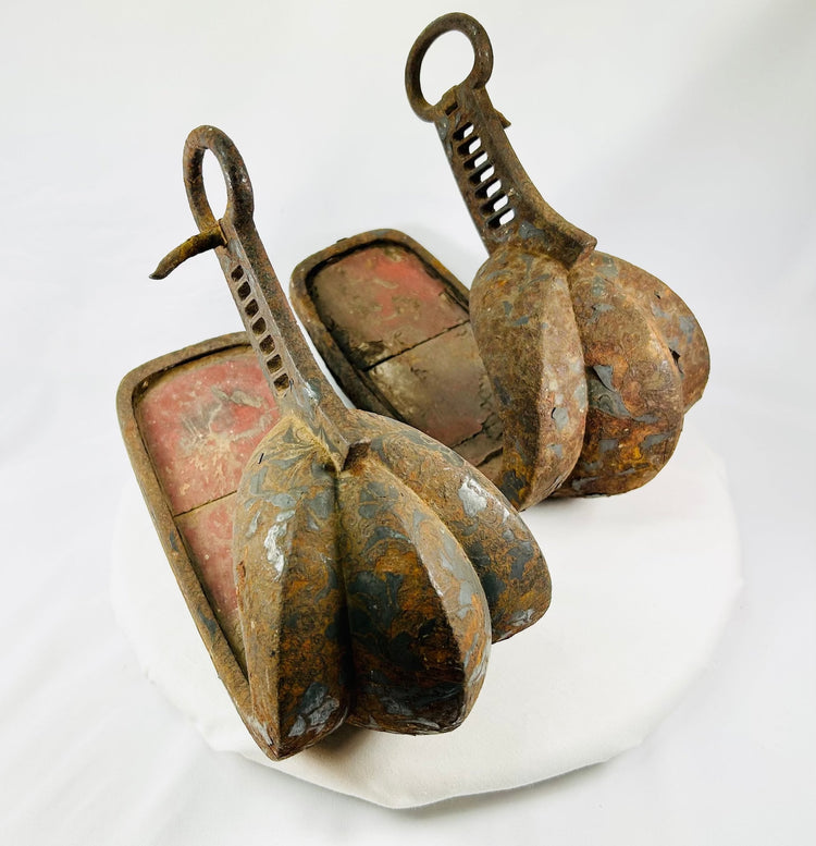 Authentic Japanese samurai stirrups from the Edo period showing original vermilion lacquer interior and remnants of painted scrollwork.