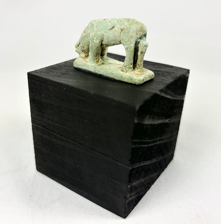 Ancient Egyptian protective shrew amulet, 664–30 BCE, pale green faience with burial wear.