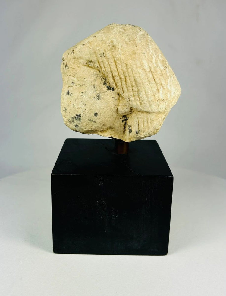 Egyptian limestone canopic jar lid, New Kingdom (1550–1070 BCE), carved in the likeness of Imsety, human-headed son of Horus, with aged patina and mounted display base.