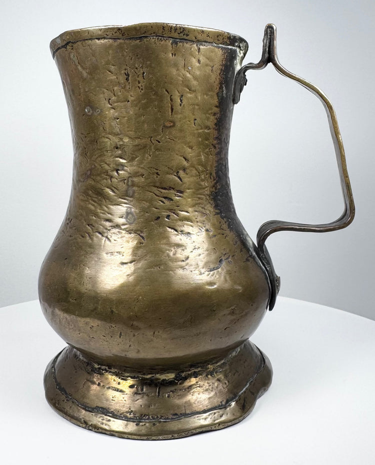 Antique Georgian brass tankard from England featuring a classic baluster-shaped body and sturdy curved handle.