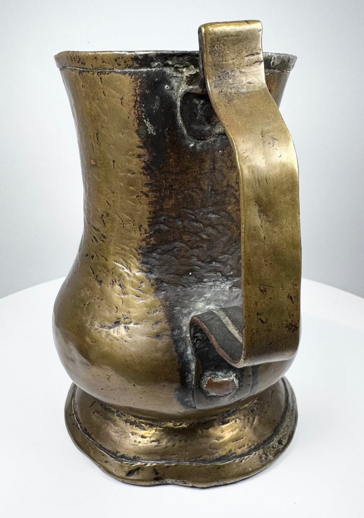 English 18th-century brass ale tankard showing traditional Georgian craftsmanship, cylindrical body, and decorative footed base.