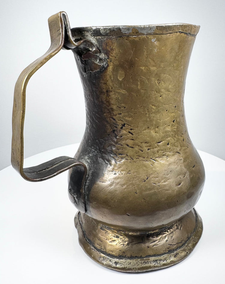 Historic George II brass tankard with open top, flared rim, curved handle, and warm antique golden finish.