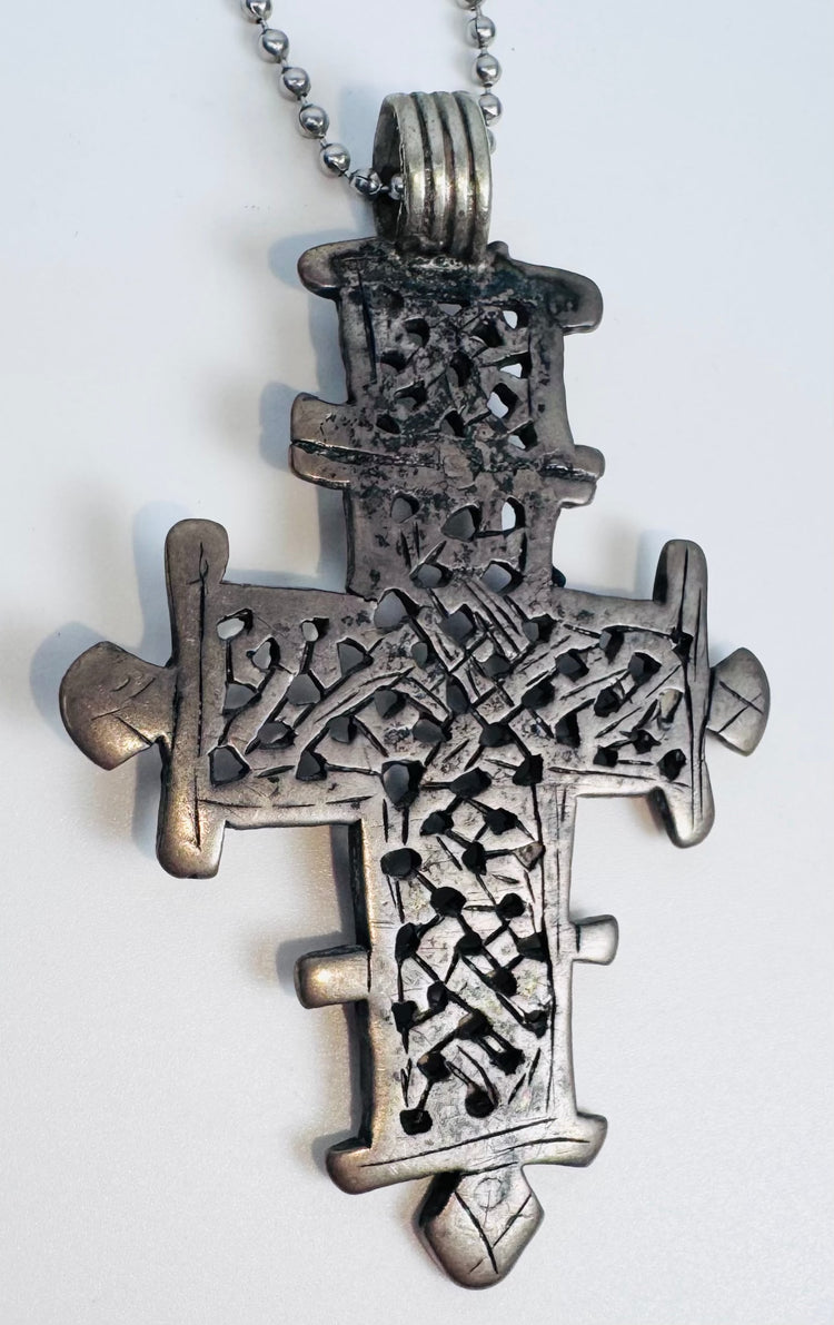 Handcrafted Ethiopian Coptic devotional cross pendant with pierced lattice pattern and suspension loop.