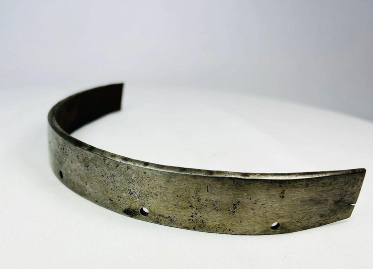 Close-up of forged steel texture on 17th-century armor band, showing hammer marks, patina, and wear from use.