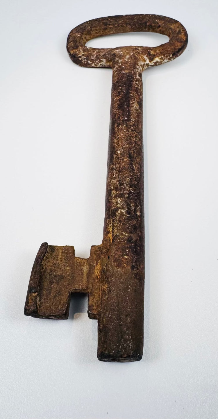 Large antique iron key from 18th-century Europe with classic oval bow and functional locksmithing design.