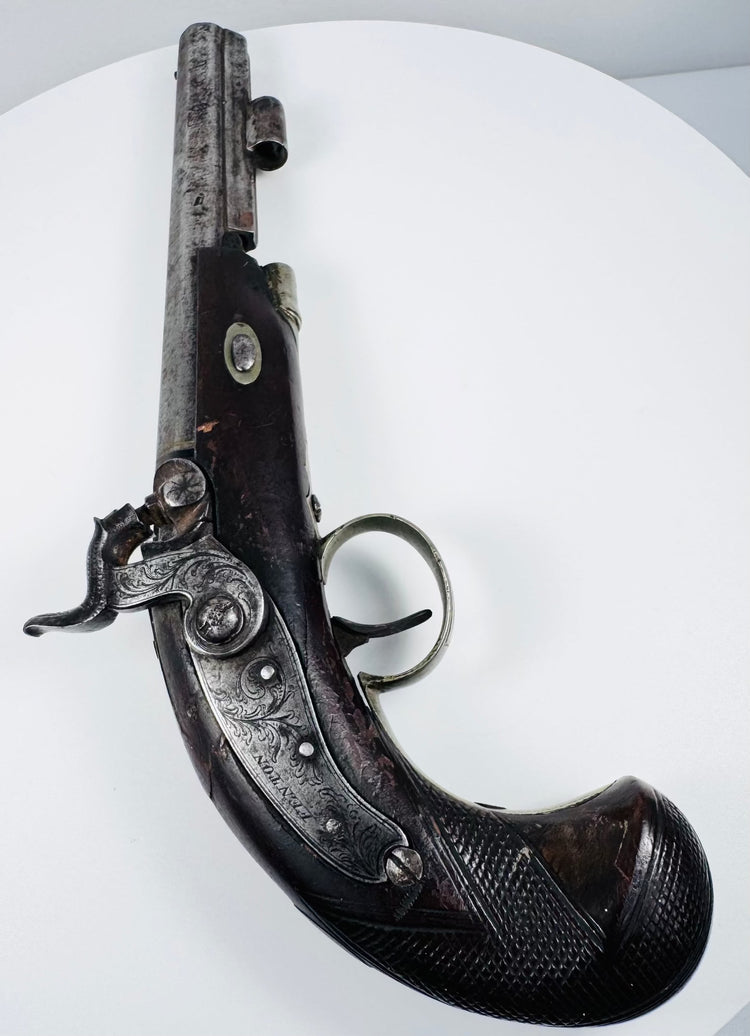 Historic English percussion pistol with dark walnut stock, ornate metalwork and London-marked barrel