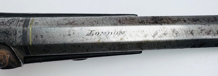 Close-up of antique percussion pistol lock and trigger assembly with decorative hand engraving