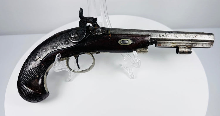 19th-century London percussion pistol with ornate engraved hardware and aged steel patina