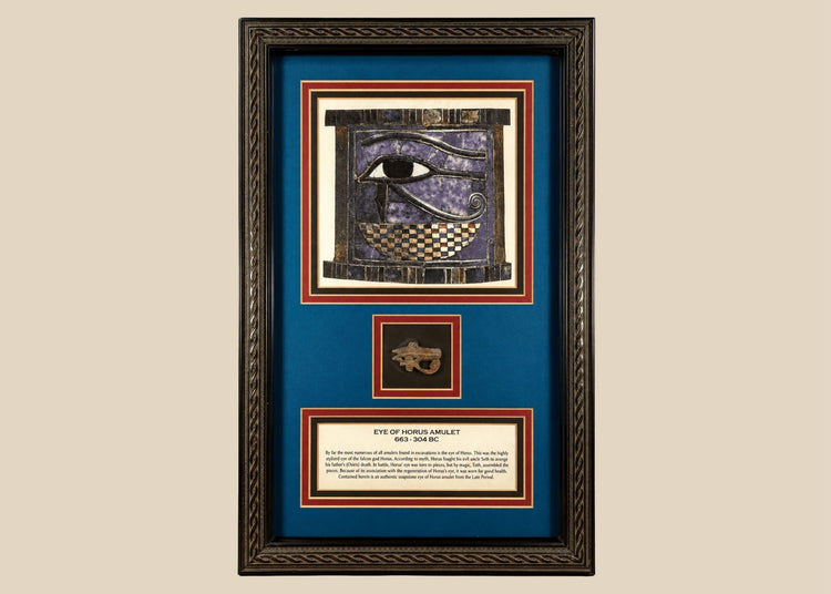 Ancient Egyptian Eye of Horus amulet dating to 663–304 BCE, mounted in an ornate framed historical display.
