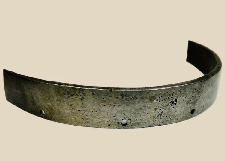 17th-century European siege armour forged steel band, curved protective element with rivet holes and aged patina from historic use.