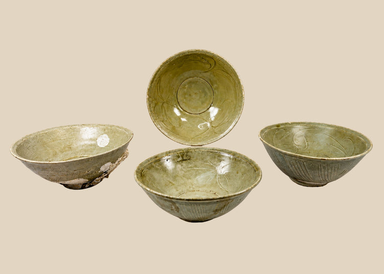 Set of four Song Dynasty celadon-glazed terracotta bowls, 12th Century CE, recovered from the Jepara Shipwreck off Central Java. Each bowl features transparent celadon glaze, incised floral interiors, linear exterior decoration, and unglazed foot rings. Marine barnacle and mussel accretions attest to maritime provenance, reflecting Song-era craftsmanship and trade across Southeast Asia.