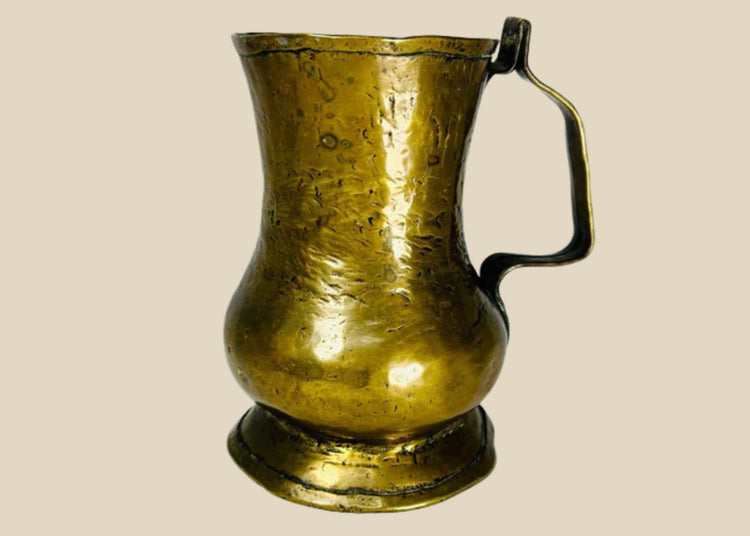 18th-century George II brass baulster tankard from England, circa 1727–1760. Cylindrical body with single handle, lidless design, and natural patina. Classic Georgian drinkware reflecting everyday use in taverns and homes, combining practicality and period craftsmanship.