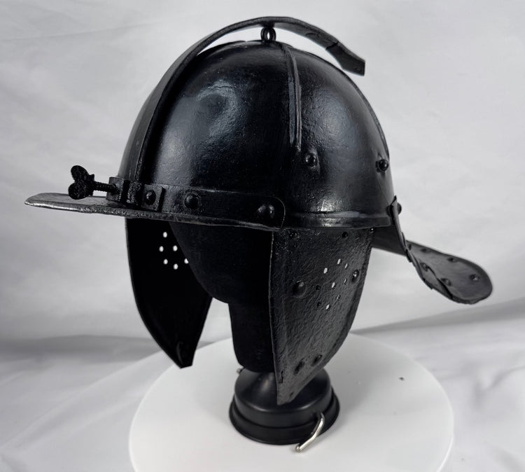 Historic Northern European cavalry helmet with pierced ear guards, adjustable nasal bar, and aged black finish.