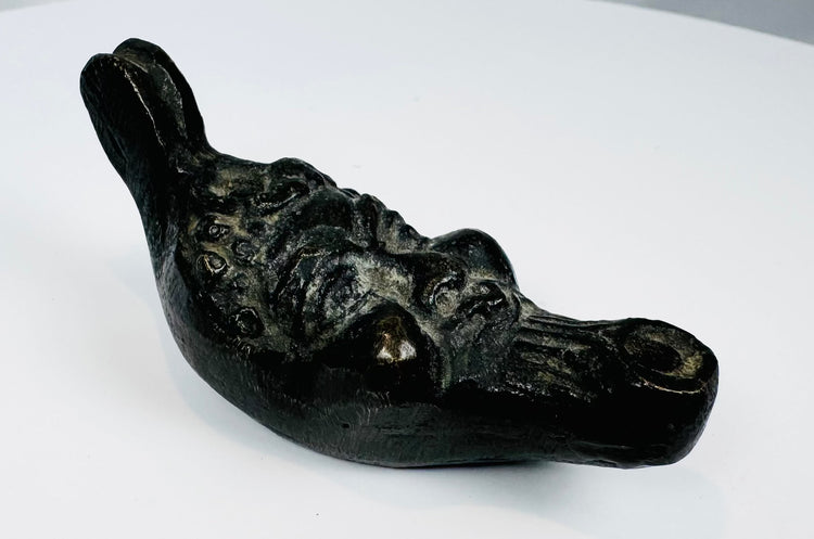 Nineteenth-century grotesque mask-form oil lamp featuring a mythological satyr face and suspension holes.