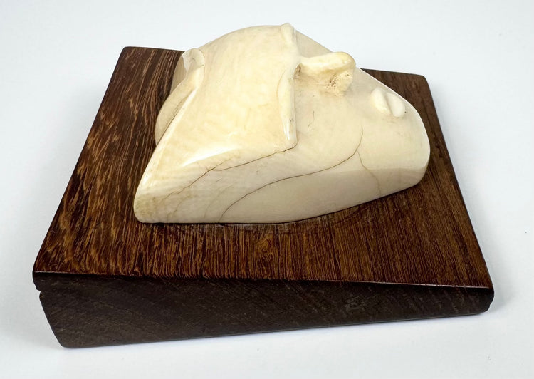 Hand-carved bone mask-form sculpture showcasing a contemplative expression, natural patina, and elegant mid-century modern design.