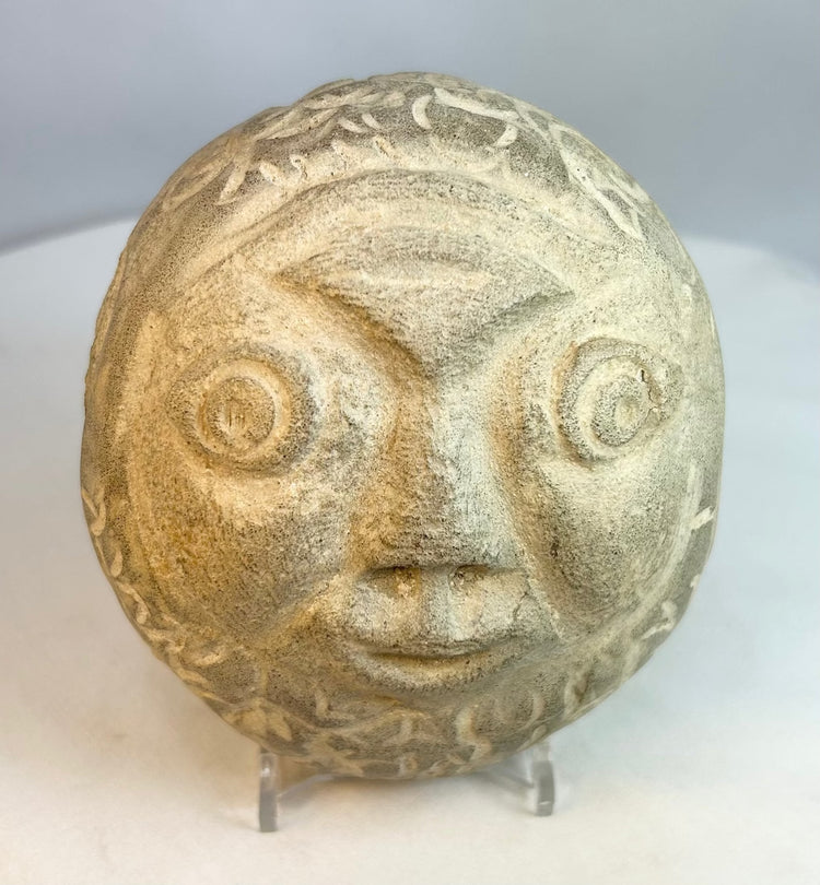 Primitive-style carved stone head showing natural stone coloration and aging