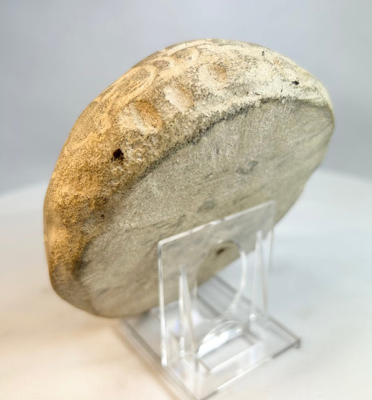 Back view of carved stone sculpture showing smooth weathered surface