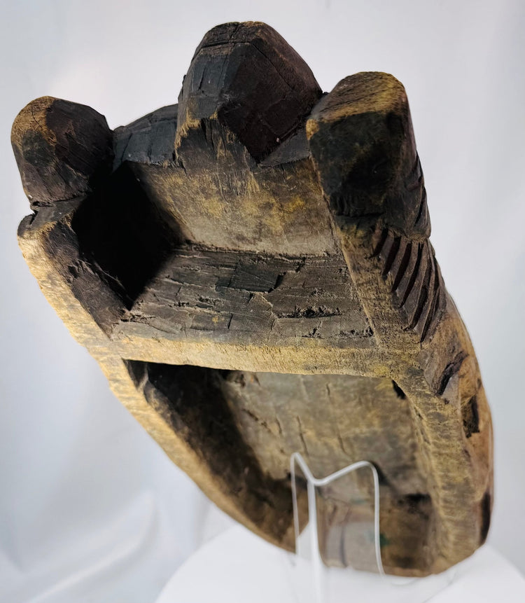 Historic African ceremonial mask with hand-carved details, weathered pigment, and spiritual symbolism.
