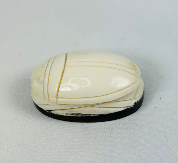 Hand-carved East Asian scarab-form talisman mounted on dark oval base