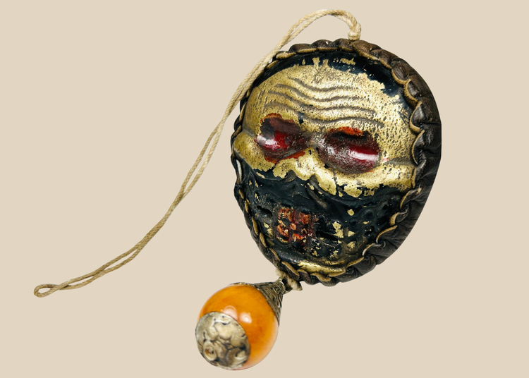 Himalayan protective skull mask amulet with leather backing and ritual drop