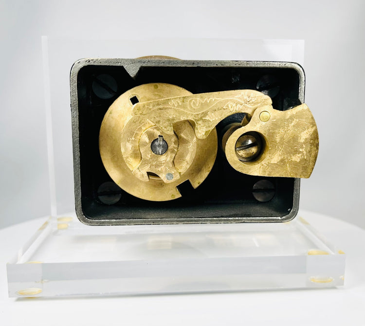 Antique brass dial safe lock front showing engraved numbers and maker mark