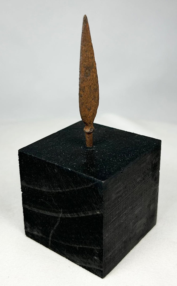 Authentic ancient iron projectile point showing aged patina and archaeological surface texture