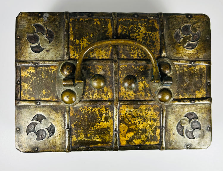 Antique iron-bound valuables chest with arched carrying handle, gilt patterned panels, and original working key.