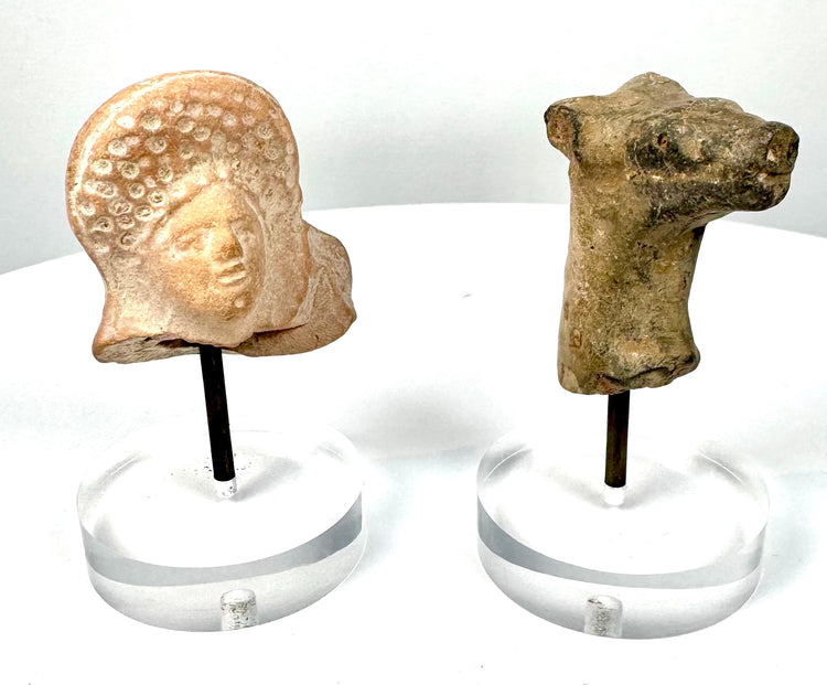 Ancient Near Eastern terracotta bovine protome featuring rounded facial contours, prominent eye details, and mineral-like surface encrustations.