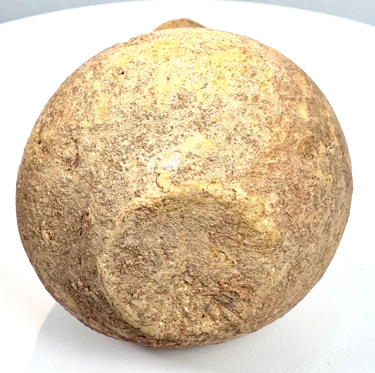 Ancient Roman-style volcanic tuff vessel displaying an undecorated sculptural form, porous texture, and visible fissure along its lower body.