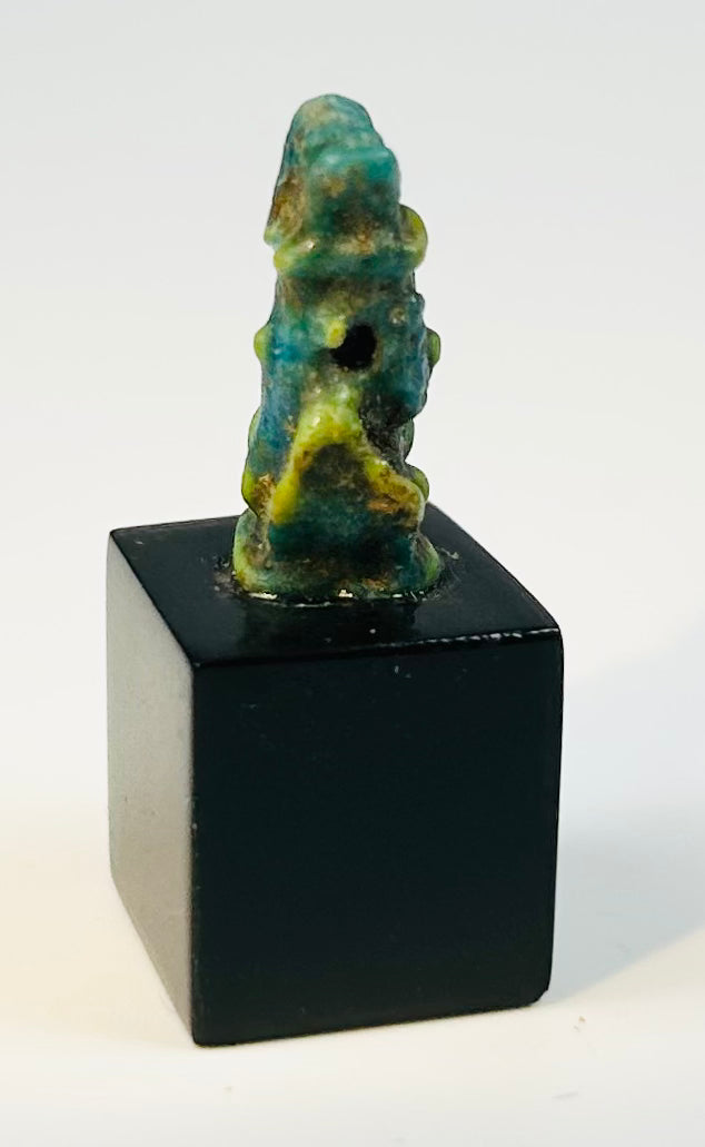 Late Period Egyptian faience amulet showing the dwarf god Bes in frontal pose.
