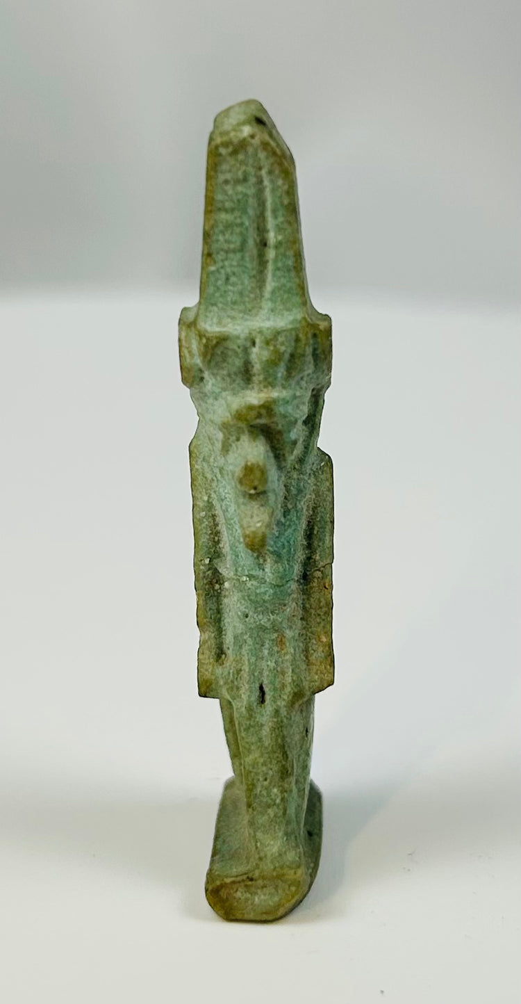 Pale green Egyptian faience amulet of the youthful god Nefertem standing in striding pose.