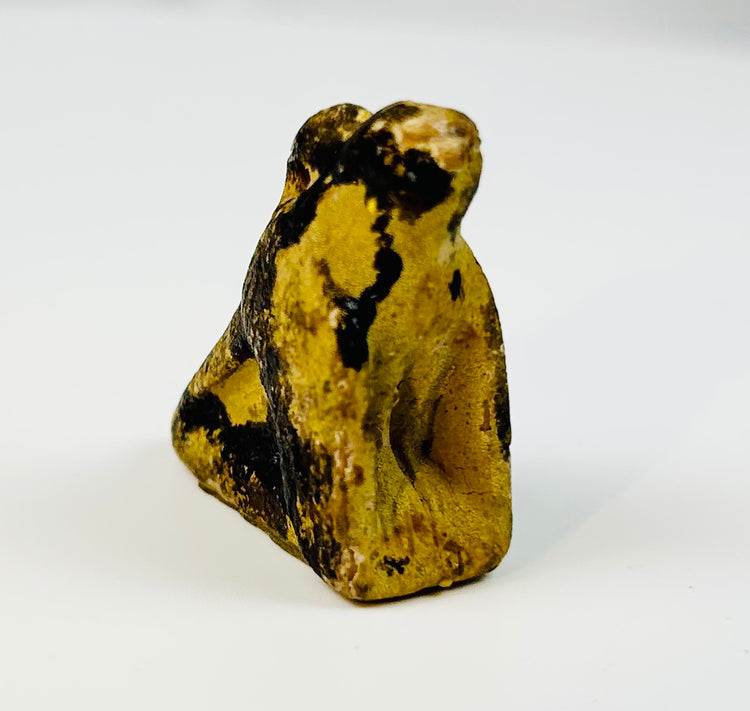 Ancient Egyptian crouching falcon amulet with suspension hole for wearing.