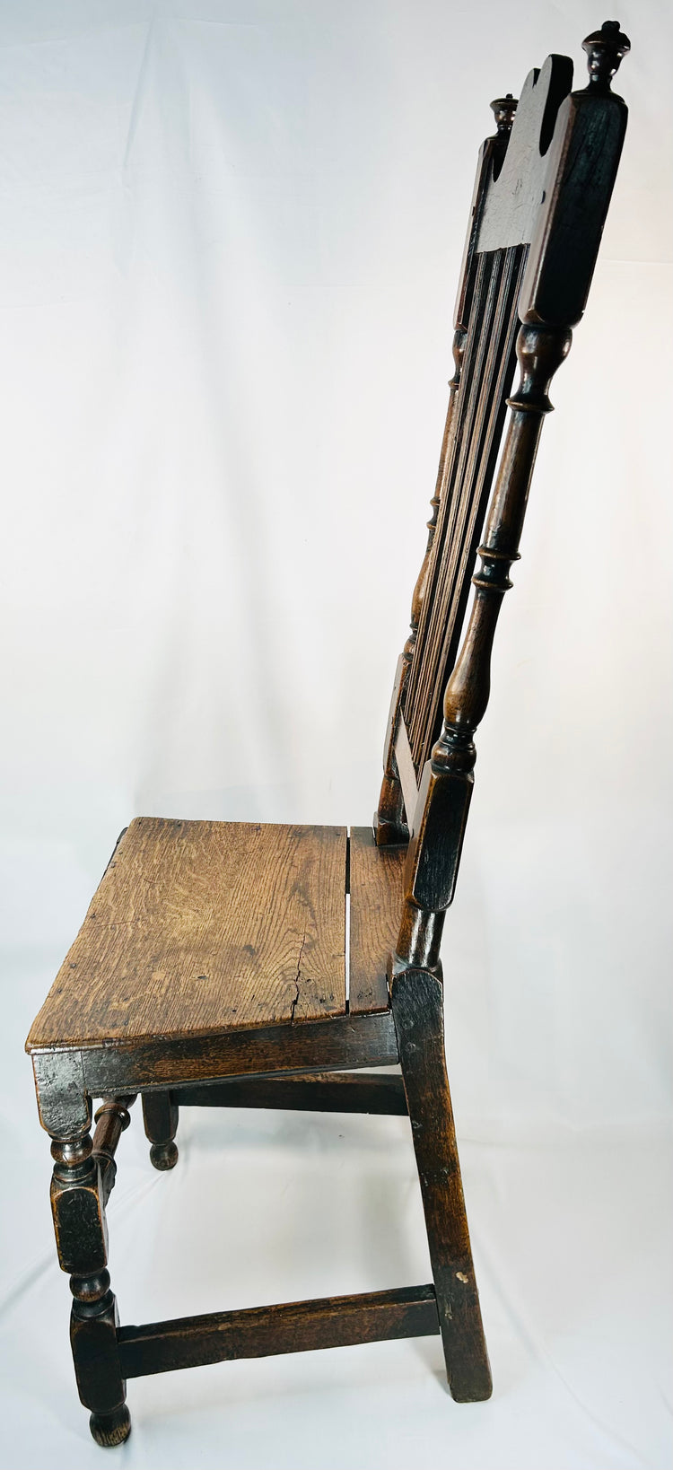 Cromwellian period oak side chair with architectural silhouette and stretcher base