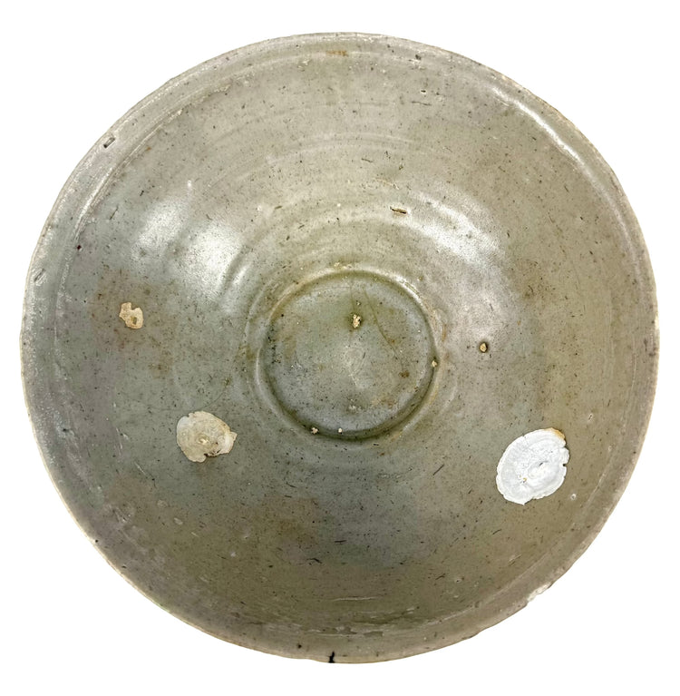 Ancient Chinese Song Dynasty celadon bowl featuring a softly translucent green glaze and finely incised floral motifs decorating its interior.