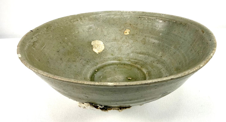 Song Dynasty ceramic bowl featuring delicate floral incising beneath a pale green celadon glaze, reflecting traditional Chinese pottery techniques.