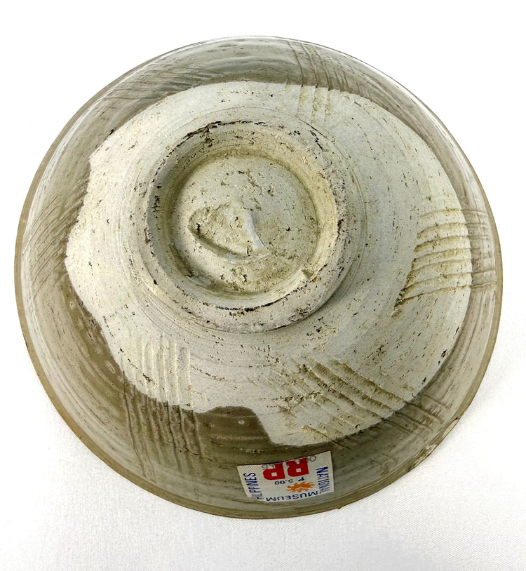 Antique Chinese celadon bowl from the 12th century CE, featuring incised exterior lines, a softly rounded profile, and an unglazed base.