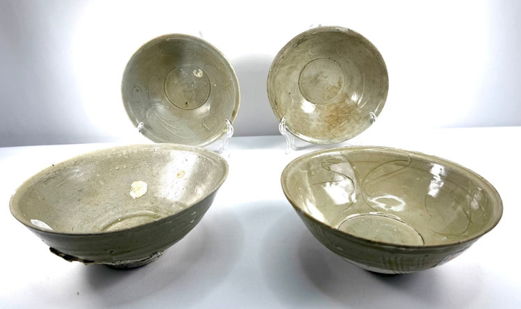Ancient Chinese celadon pottery collection consisting of four heavily potted Song Dynasty bowls with delicate green glazes and archaeological marine deposits.