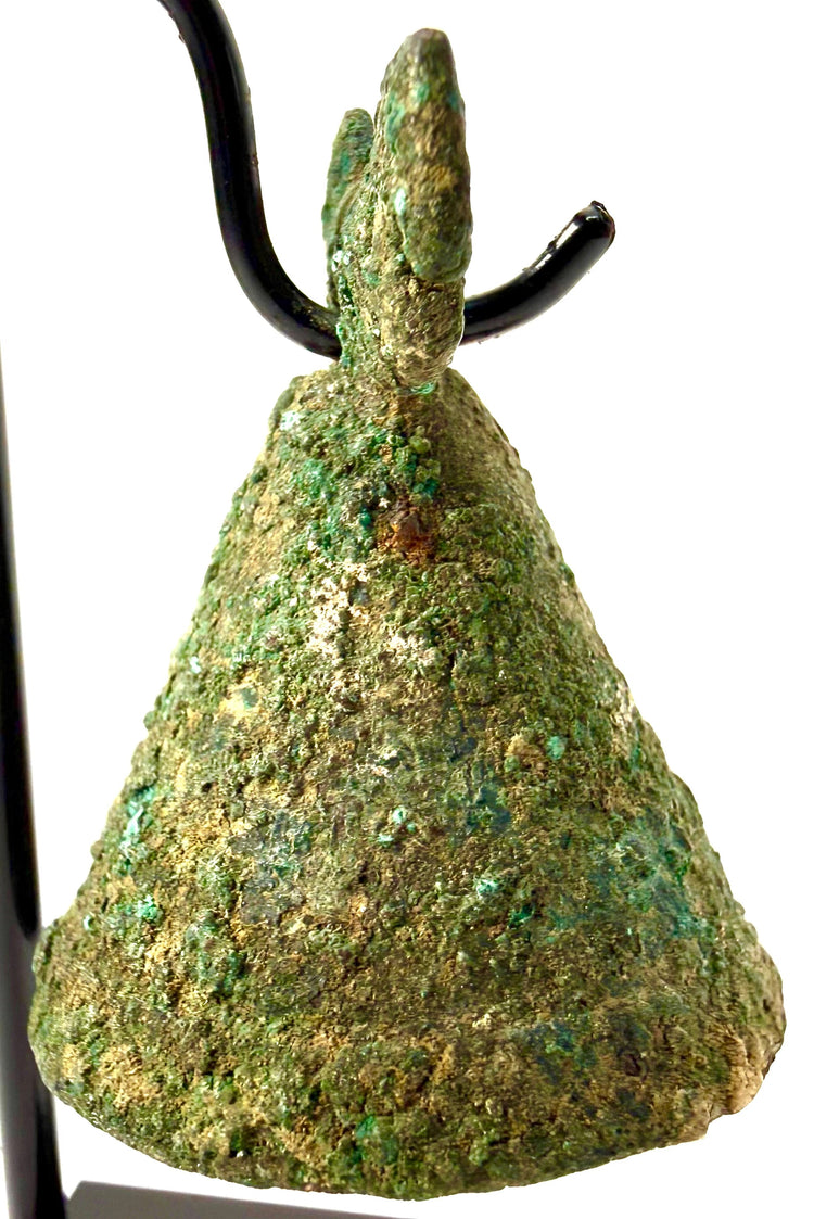 Archaeological Parthian bronze bell displaying malachite-green corrosion, surface oxidation, and sculpted horse-head ornaments surrounding its suspension opening.