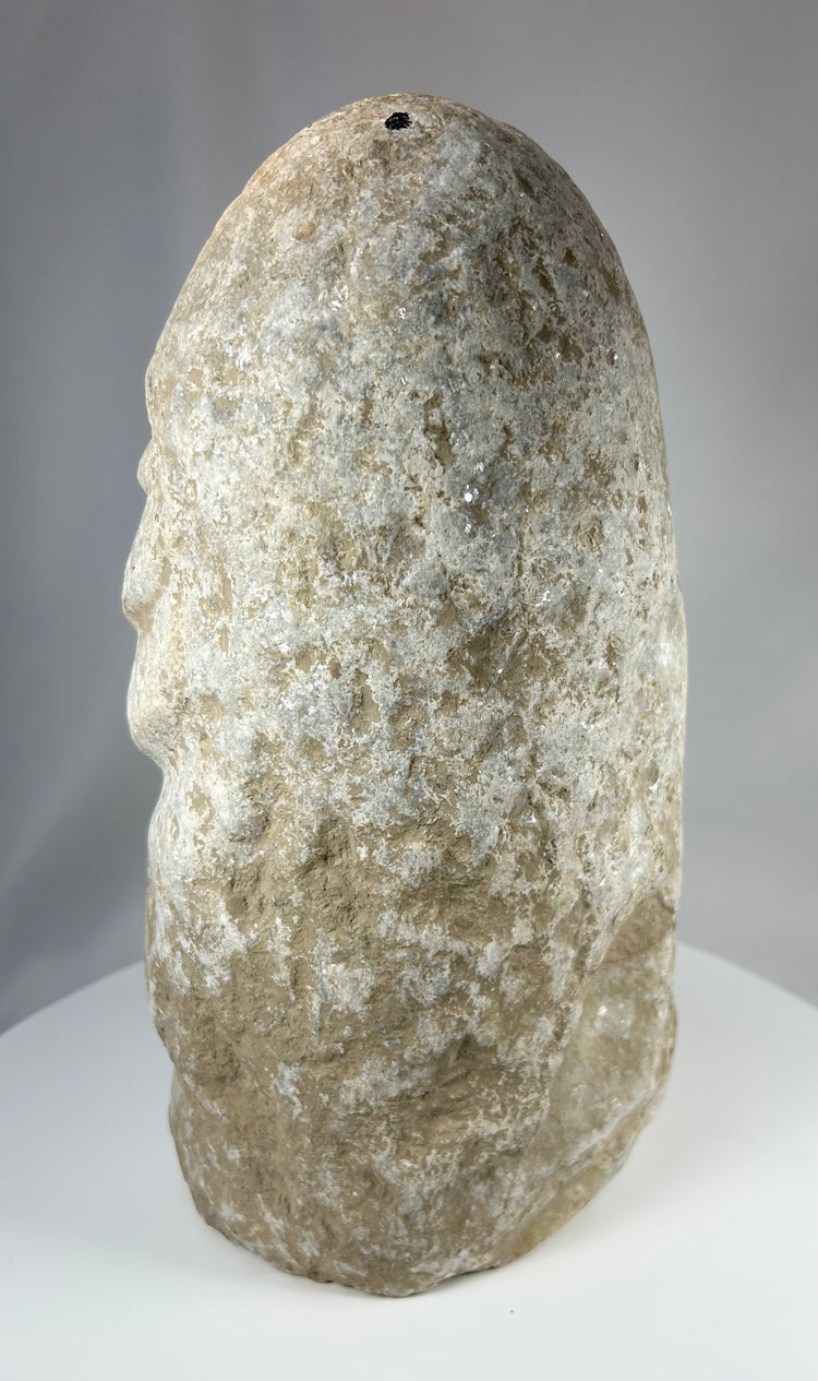 Ancient limestone figure with abstract human form and carved head detailing