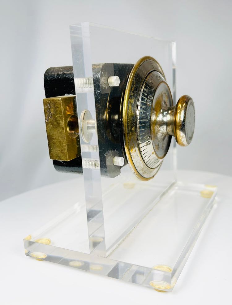 Antique safe lock display showing brass dial and exposed mechanical system