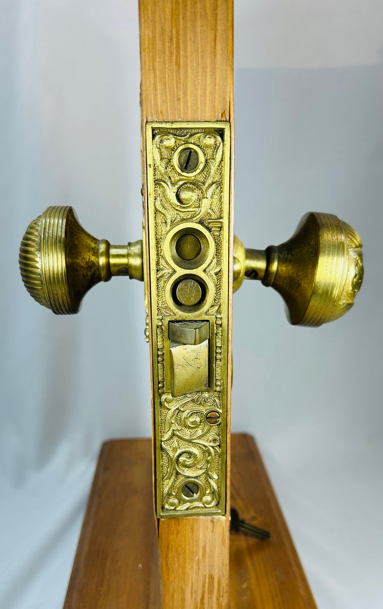 Antique brass door hardware set with floral detailing and demonstration mount