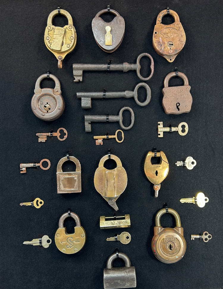 Historic padlocks and keys exhibit mounted in shadow box with mixed metal finishes