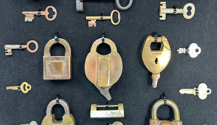 Framed display of antique locks and keys with natural oxidation and aged surfaces