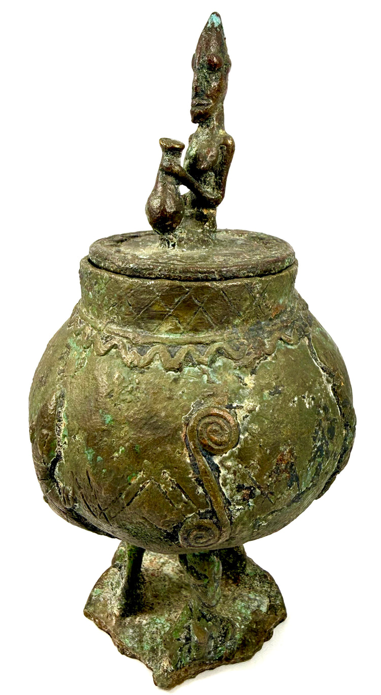 West African bronze container with a stylized standing human figure crowning its circular lid.