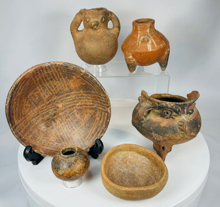 Curated collection of six Pre-Columbian pottery pieces including bowls, effigy vessels, and tripod forms