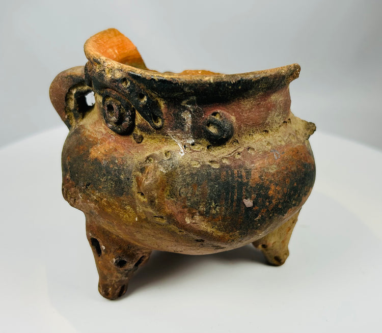 Pre-Columbian tripod vessel with burnished orange surface and three short legs